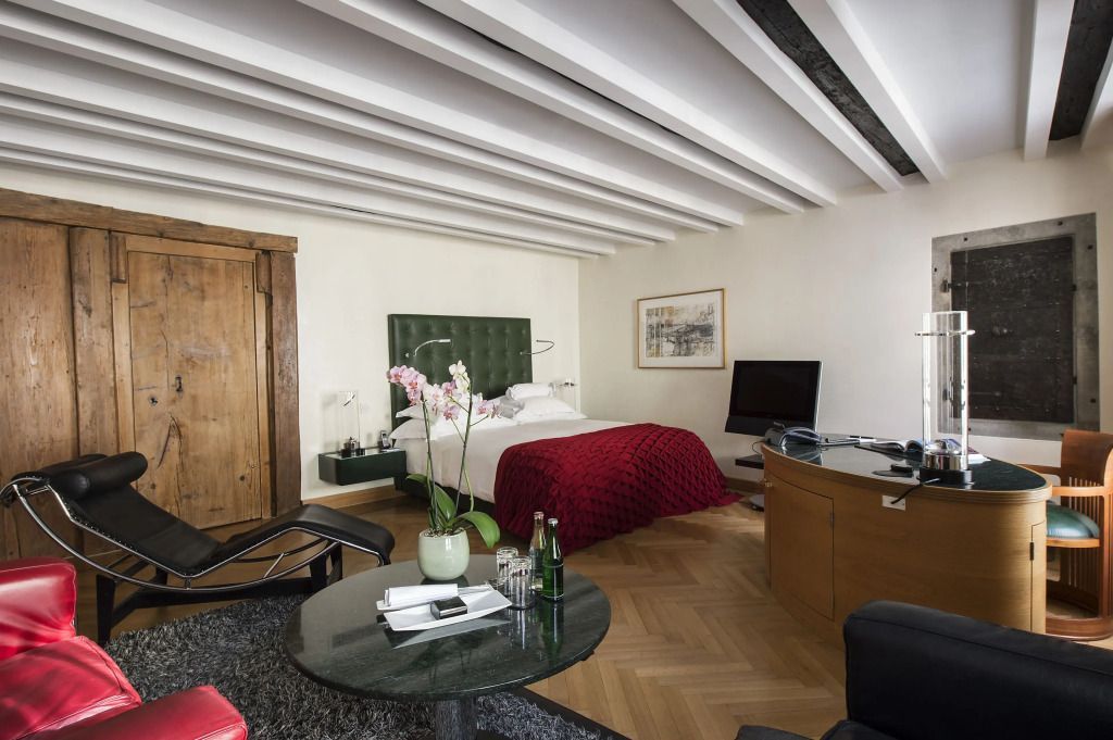 Elegantes Zimmer mit Doppelbett, grünem Kopfteil, modernem Dekor, Orchideen.