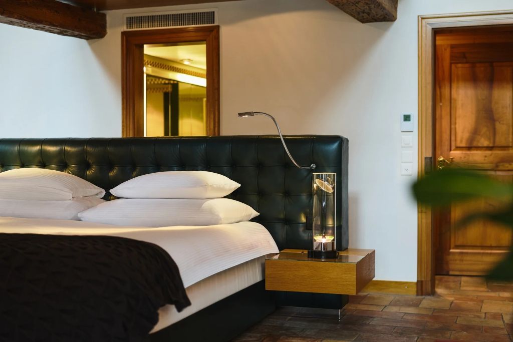 Bequemes Doppelbett mit stilvoller Beleuchtung in der Junior-Suite