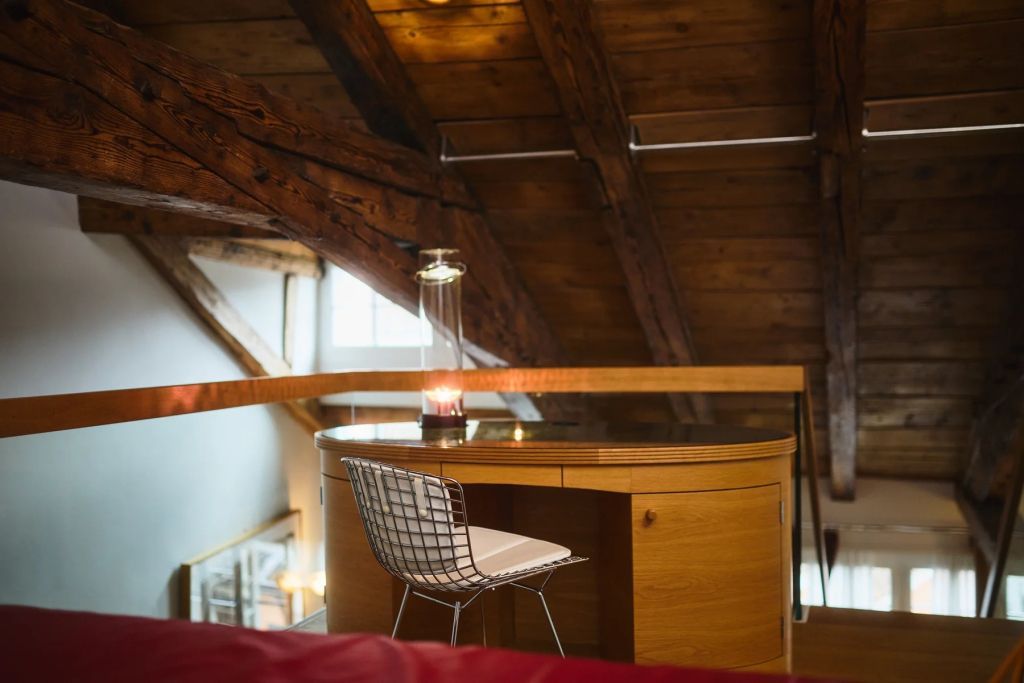Schreibbereich mit Designerstuhl unter Holzdecke in der Junior-Suite