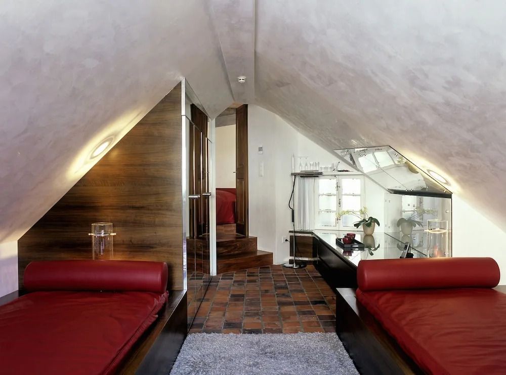 Gemütliches Dachzimmer mit zwei roten Sofas und moderner Einrichtung