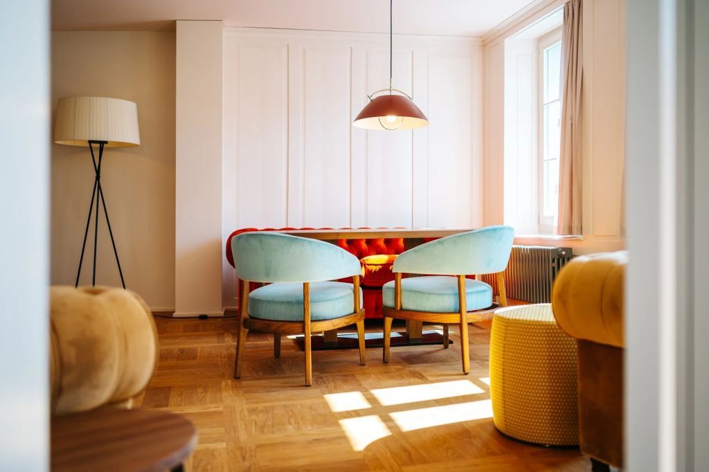 Essbereich mit hellblauen Stühlen und Designer-Lampe