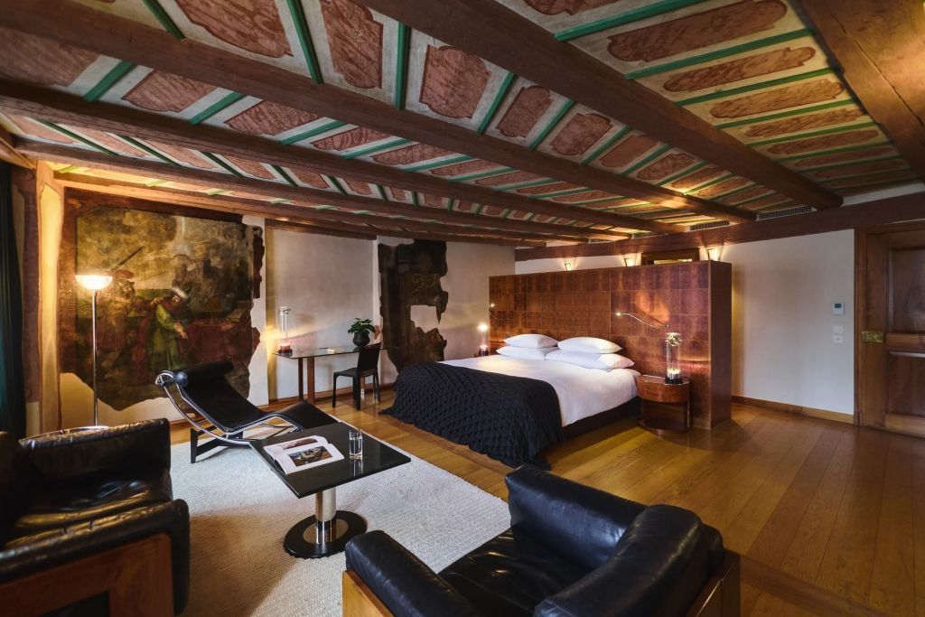 Elegante historische Junior-Suite mit Holzbalkendecke und Doppelbetten.