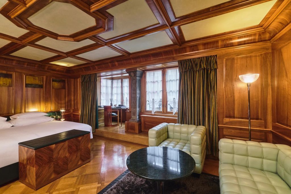Stilvolle Suite mit Holztäfelungen und gemütlicher Sitzecke.