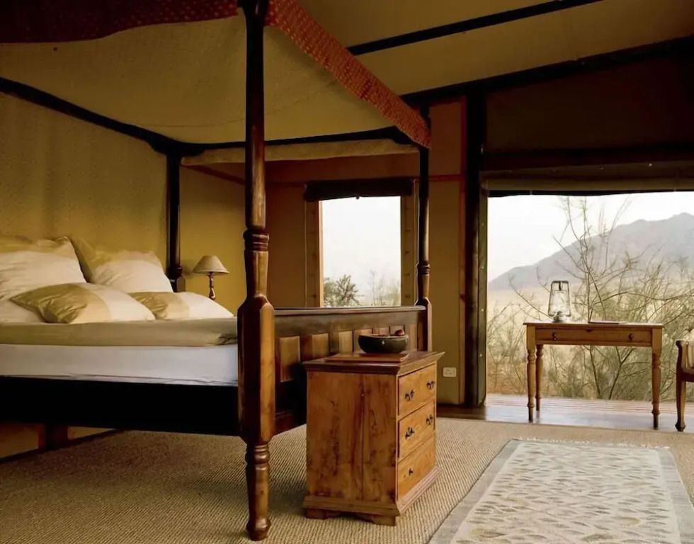 Gemütliches Standardzimmer mit Himmelbett und Blick auf die Wüstenlandschaft