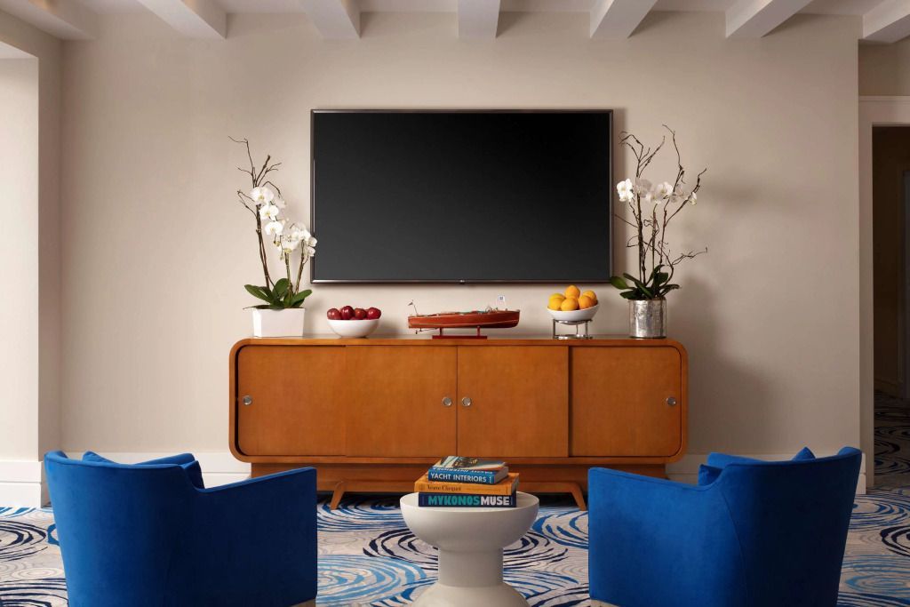 Moderner Wohnbereich mit großem Flachbildfernseher und dekorativem Sideboard