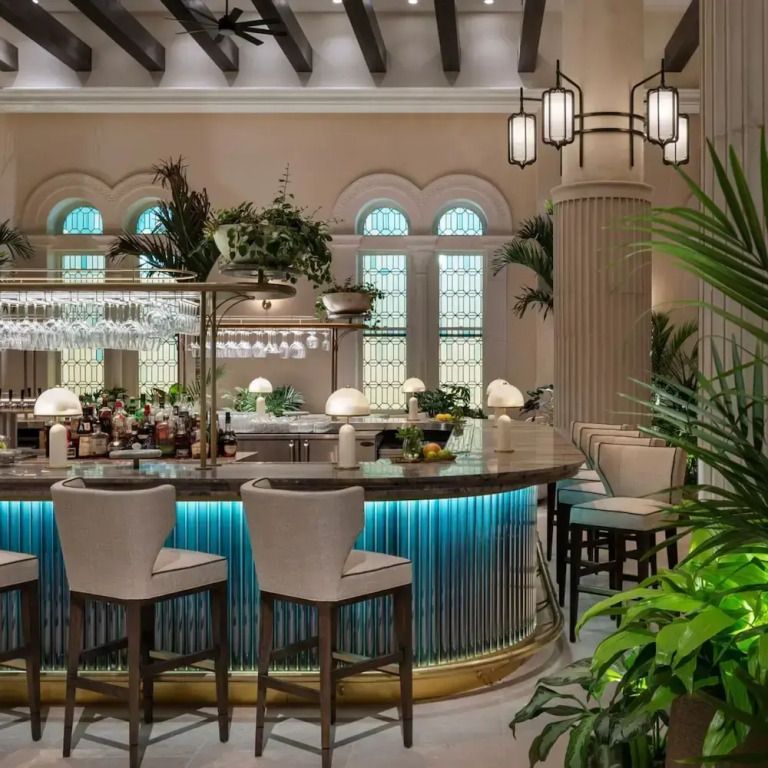 Schicke Hotelbar mit stilvoller Beleuchtung und üppigem Grün.