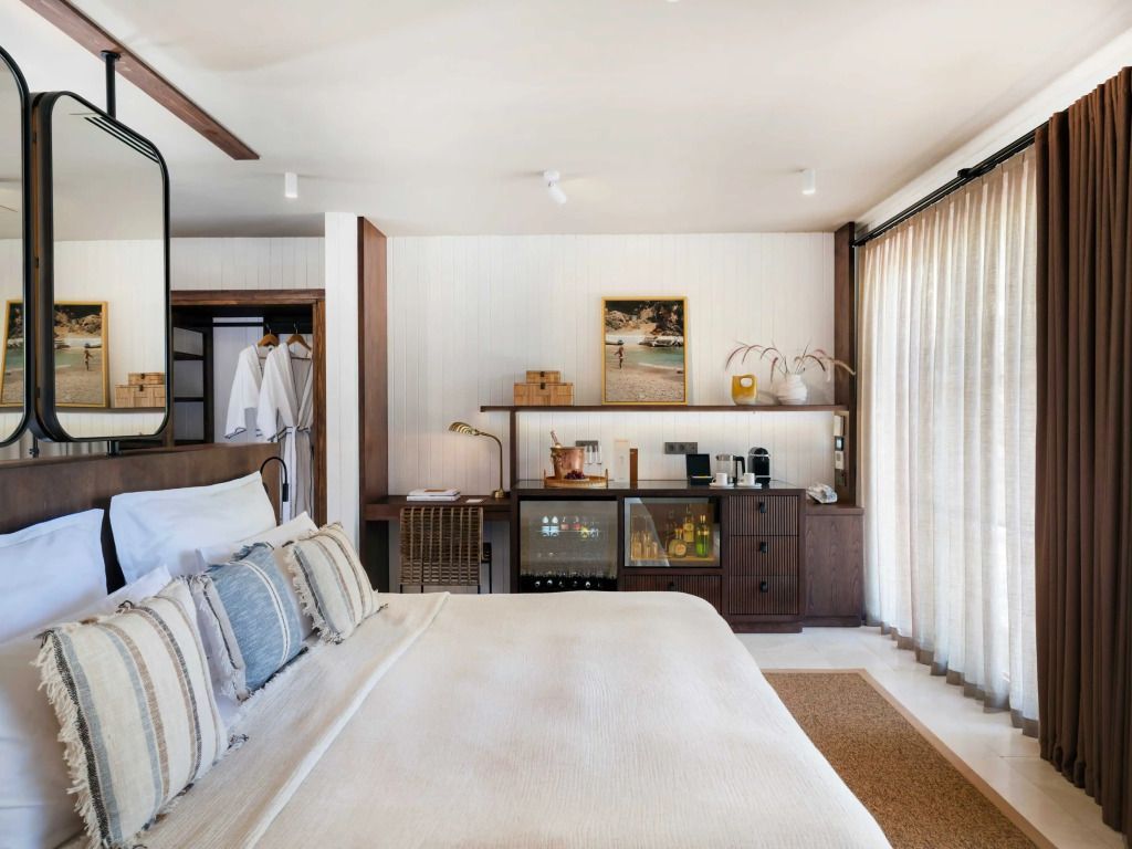 Zimmeransicht mit bequemen Bett, Minibar und gemütlicher Sitzgelegenheit.