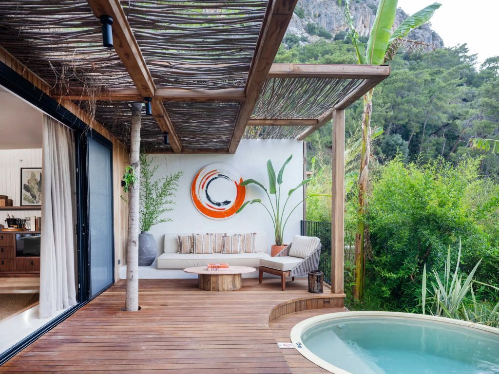Private Terrasse mit Sitzecke und Whirlpool inmitten der Natur.