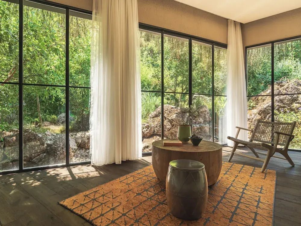 Große Fenster mit Vorhängen und Gartenblick in einer stilvollen Suite