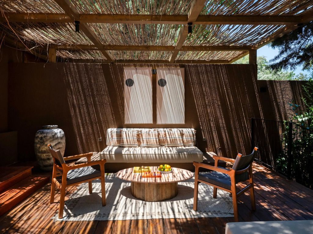 Gemütliche Terrasse mit Sitzmöbeln und Holzüberdachung im Schatten.