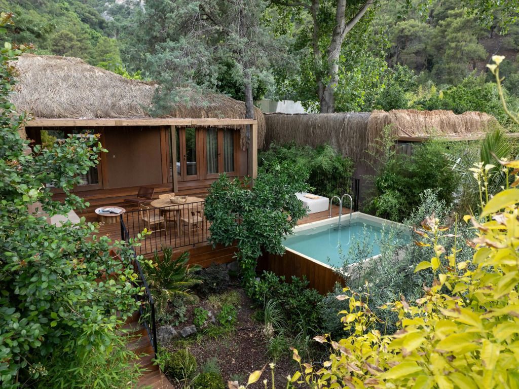 Villa mit Naturdesign und privatem Pool inmitten von Bäumen.