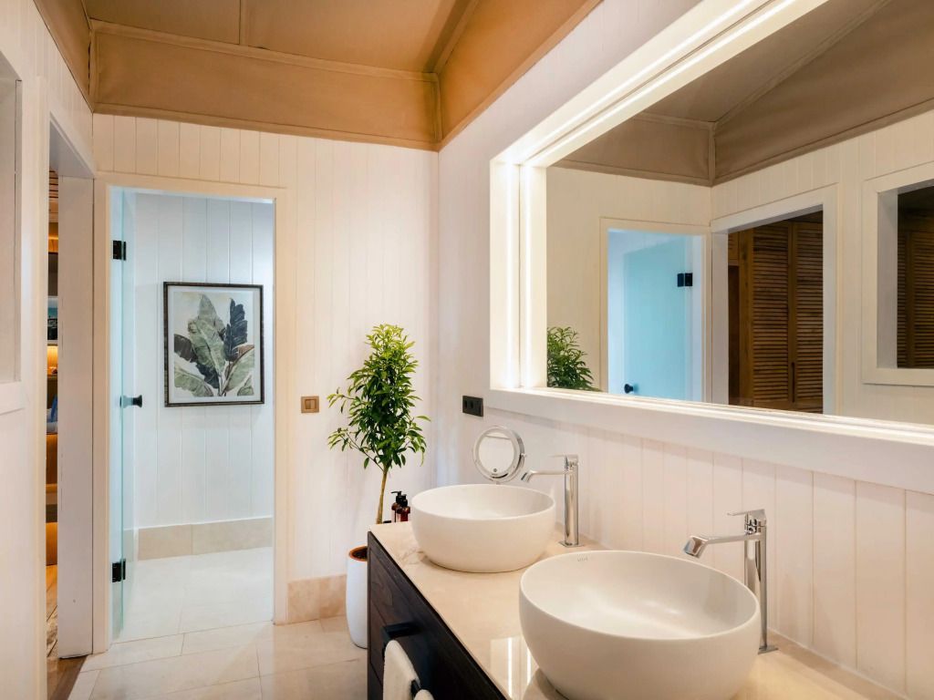 Modernes Badezimmer mit zwei Waschbecken und Pflanzenakzenten.