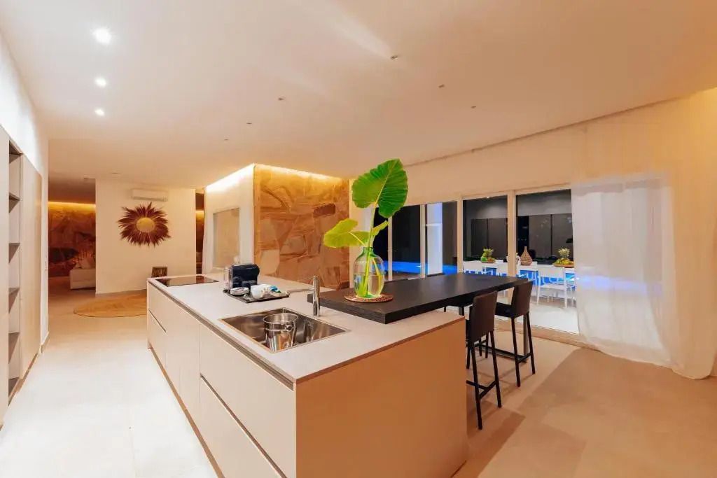 Moderne offene Küche mit Insel und Essbereich in der Villa des Ycona Luxury Resorts