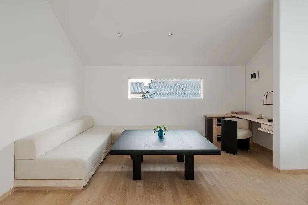 Lounge-Bereich mit Sofa und großem Tisch in neutralen Farben