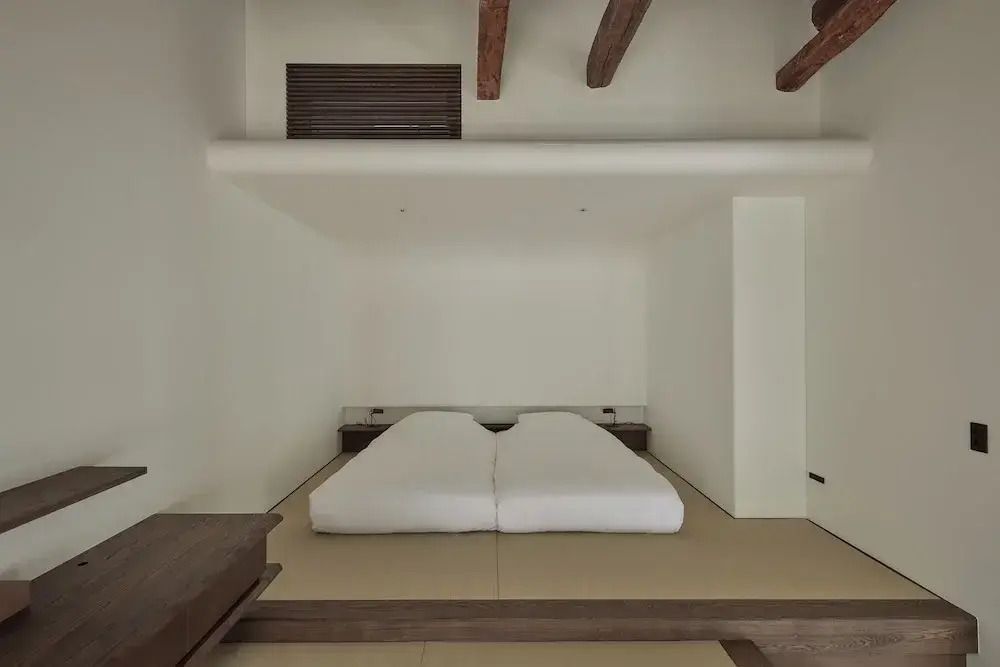 Japanischer Futon-Stil in minimalistischem Hotelzimmer mit Balken an der Decke