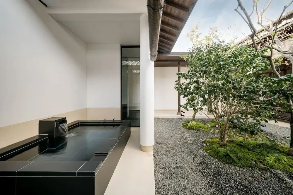 Gartenbereich mit kleinem Brunnen und gepflegtem Grün