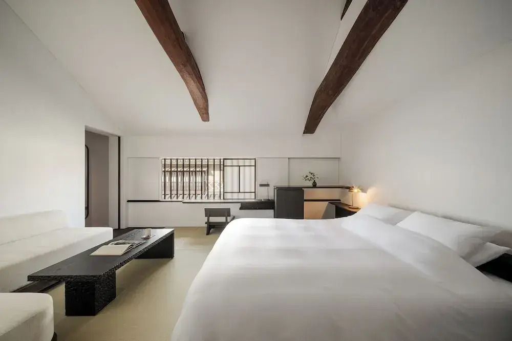 Helles Zimmer mit Holzbalken und großem Bett im Yoruya Hotel