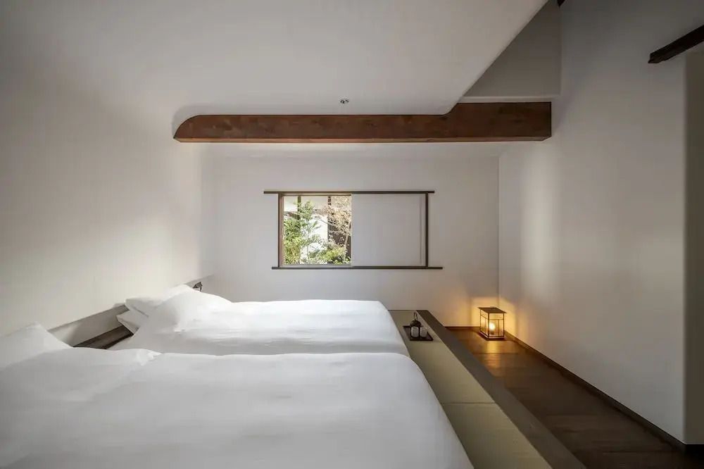 Schlafzimmer mit zwei Betten und einem Fenster mit Gartenblick