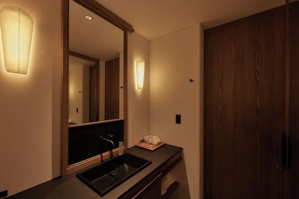 Elegante Badezimmer mit stilvollem schwarzem Waschbecken und Holzverkleidung