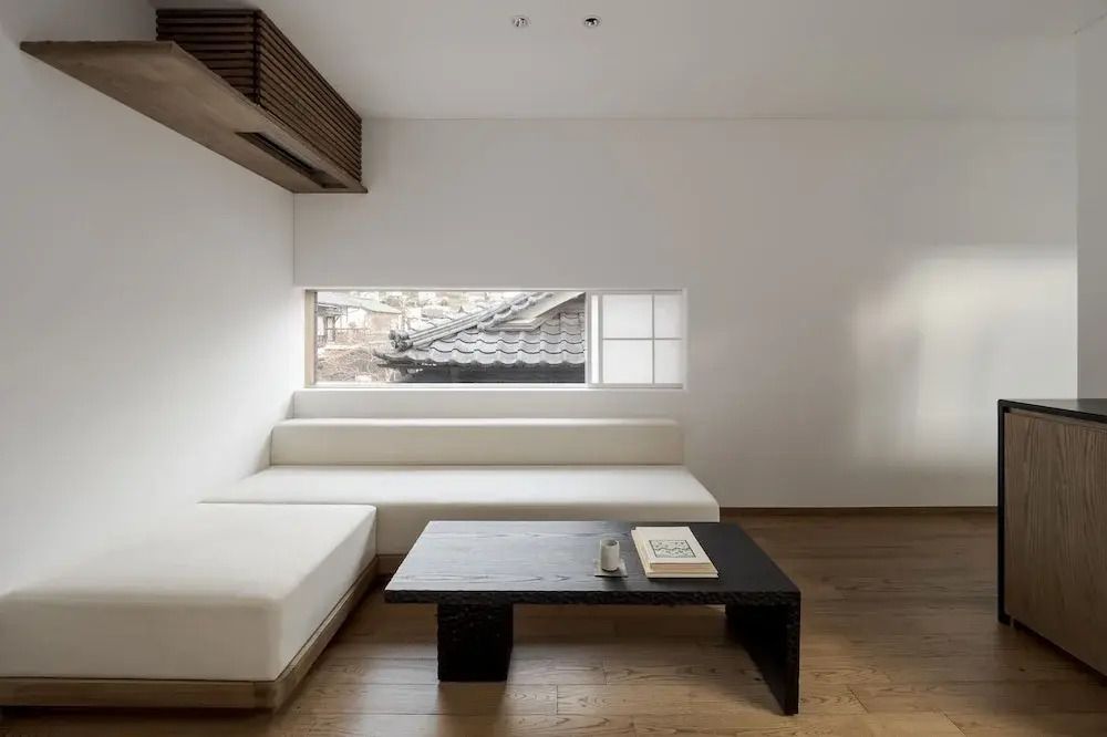 Minimalistische Sitzecke mit weißen Sofas und modernem Couchtisch