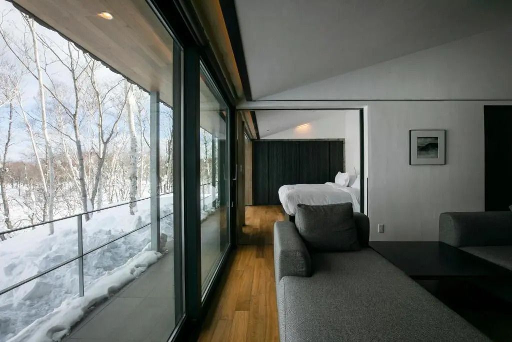 Premium Zimmer mit Panoramafenster und Blick in die winterliche Natur