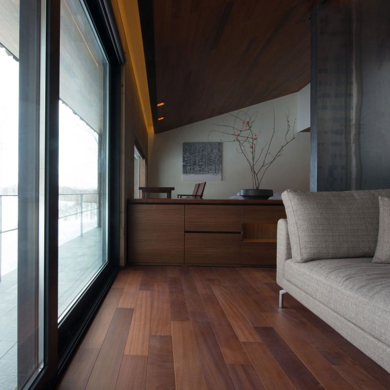Geräumiges Zimmer mit hölzernem Boden und moderner Vertäfelung. Große Fenster mit Aussicht.