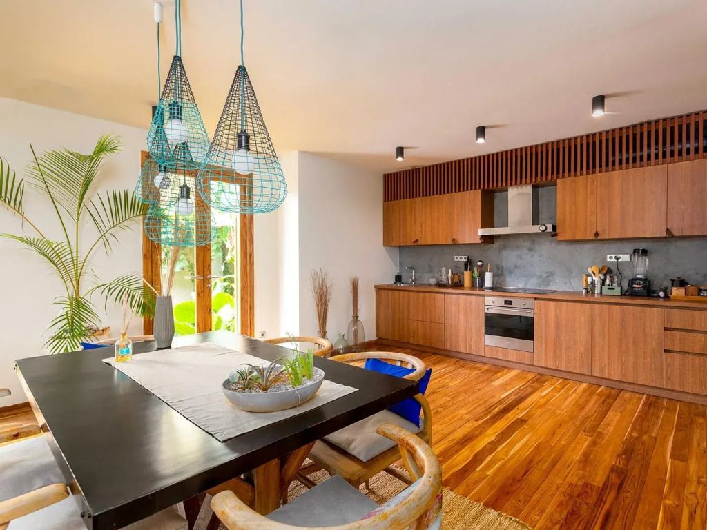Elegante moderne Küche in einer Garten-Villa mit Holzfußboden und stilvollen Hängeleuchten