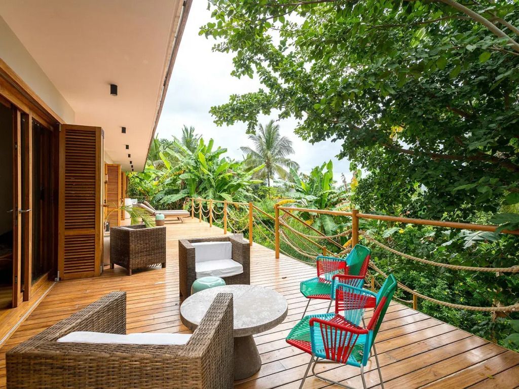 Geräumige Terrasse mit bequemen Sitzgelegenheiten und Blick auf tropische Vegetation