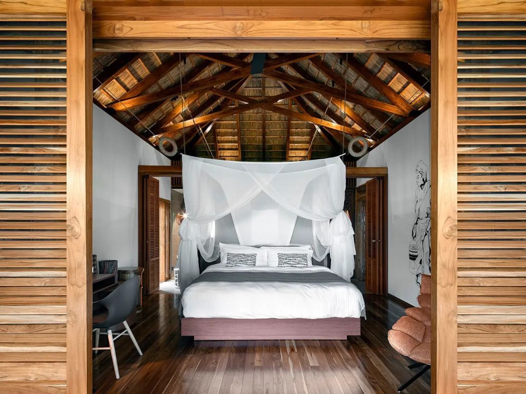 Geräumiges Schlafzimmer mit Himmelbett und Holzbalkendecke