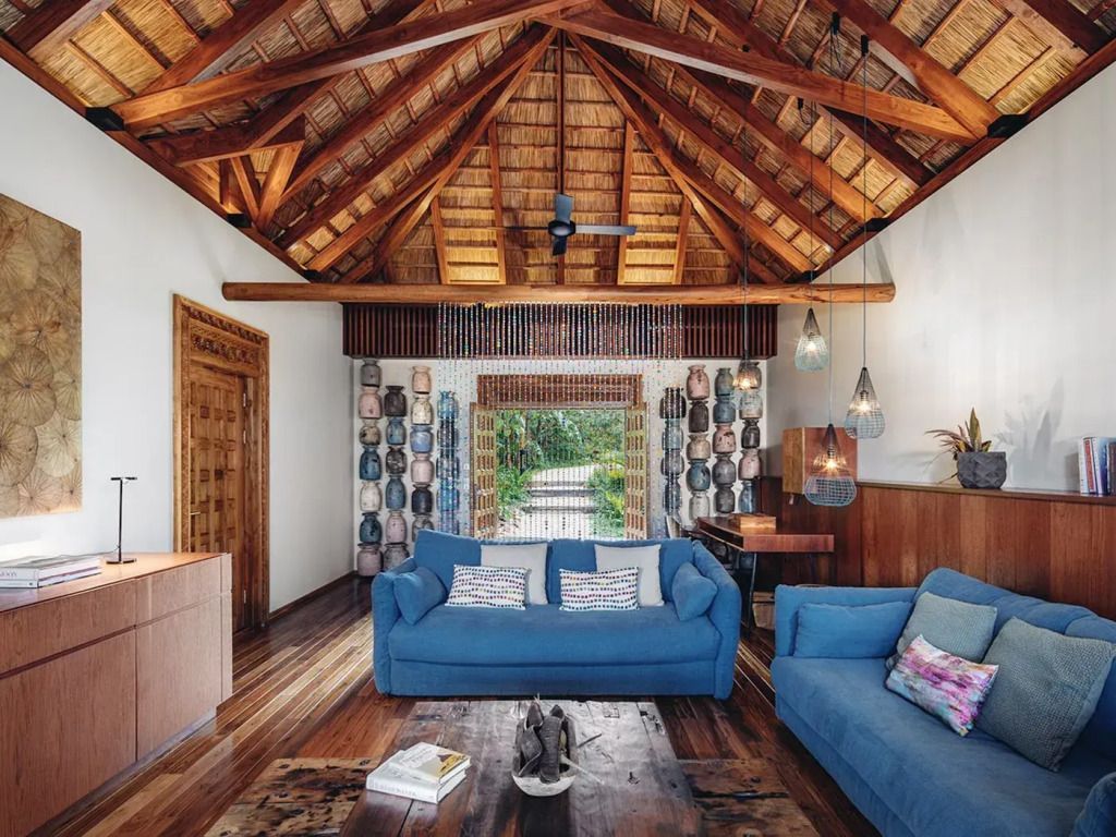 Wohnbereich mit blauen Sofas und Holzbalkendecke in der Suite