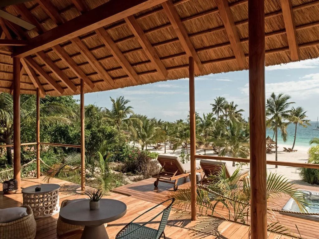 Veranda mit Blick auf Palmen und Ozean vor Zuri Zanzibar Resort