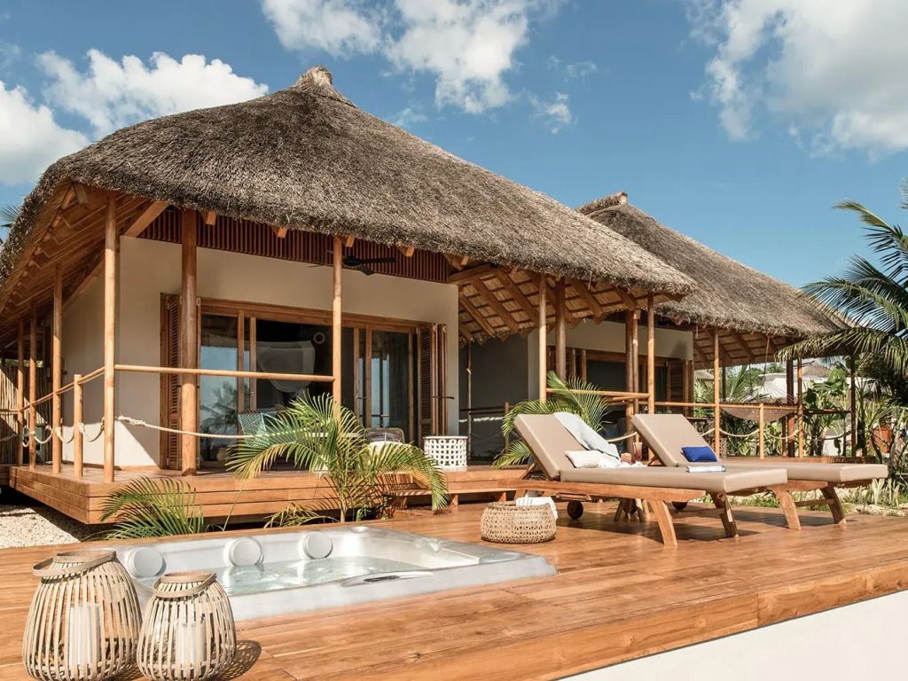 Außenansicht der Villa mit Strohdach und Terrasse im Zuri Zanzibar