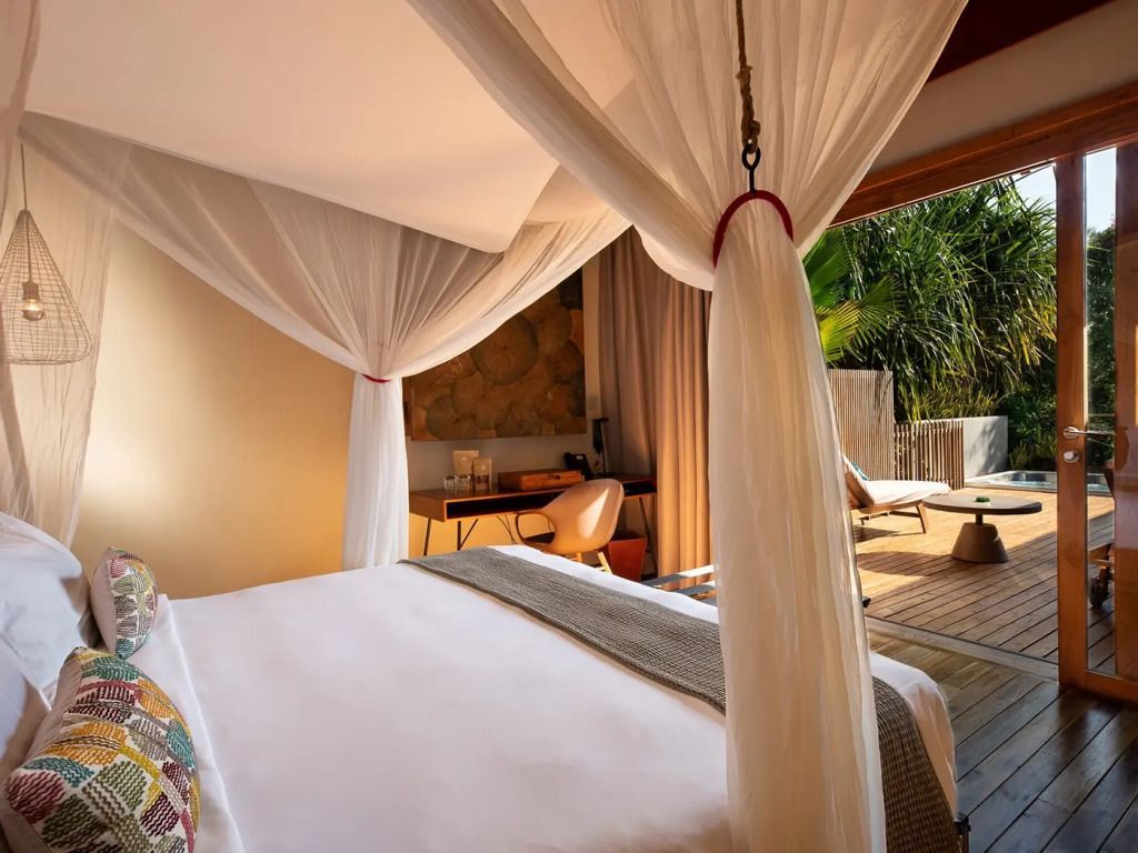 Helles Schlafzimmer mit Himmelbett und Sonnenterrasse in der Oceanfront Villa