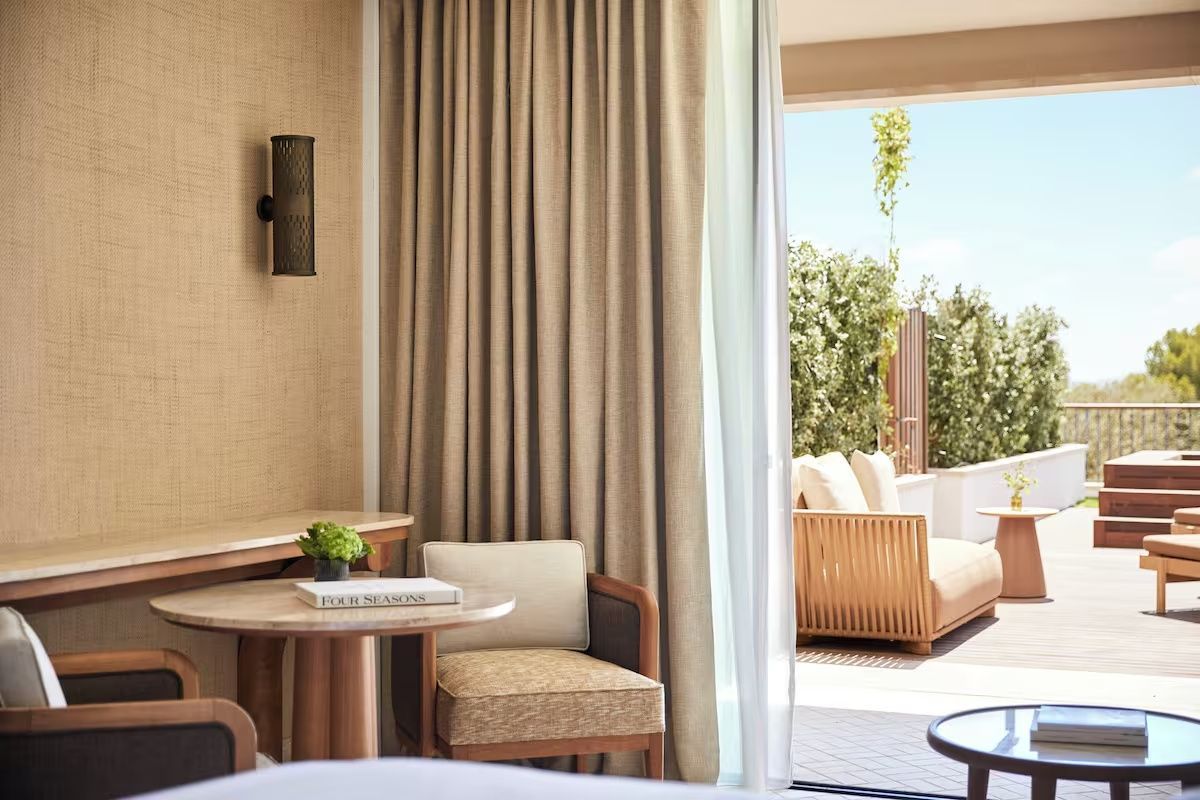 Sitzbereich im Zimmer mit kleinem Tisch, Sessel und Blick auf die Terrasse.