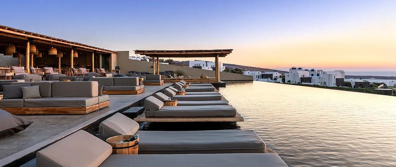 Infinity-Pool mit Liegen bei Sonnenuntergang und moderner Architektur