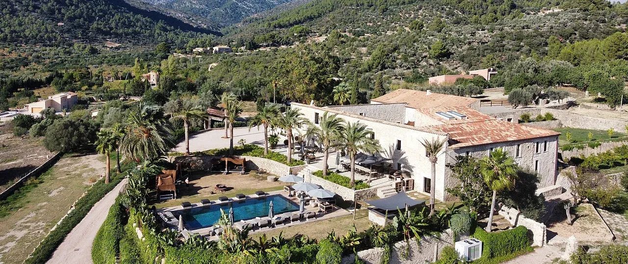Luxuriöse Villa mit Pool und Palmen in einer bergigen Landschaft