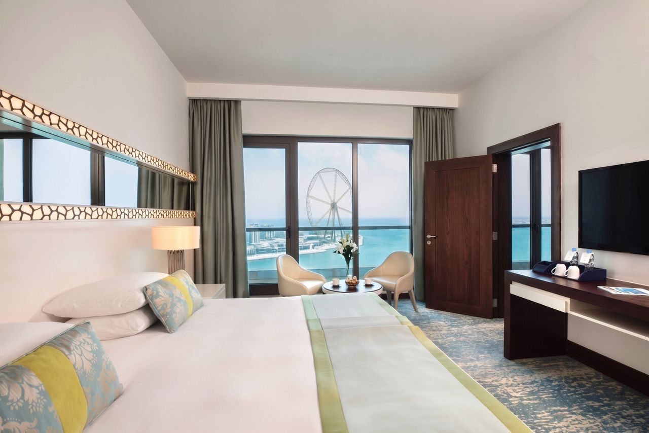 Elegantes Hotelzimmer mit Blick aufs Meer und gemütlichen Sitzgelegenheiten
