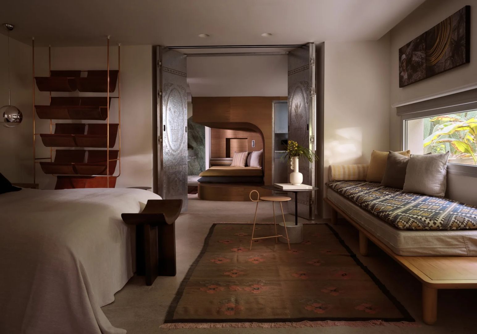 Geräumige Suite mit Doppelbett, Teppich, Sitzecke und Blick in ein angrenzendes Schlafzimmer.