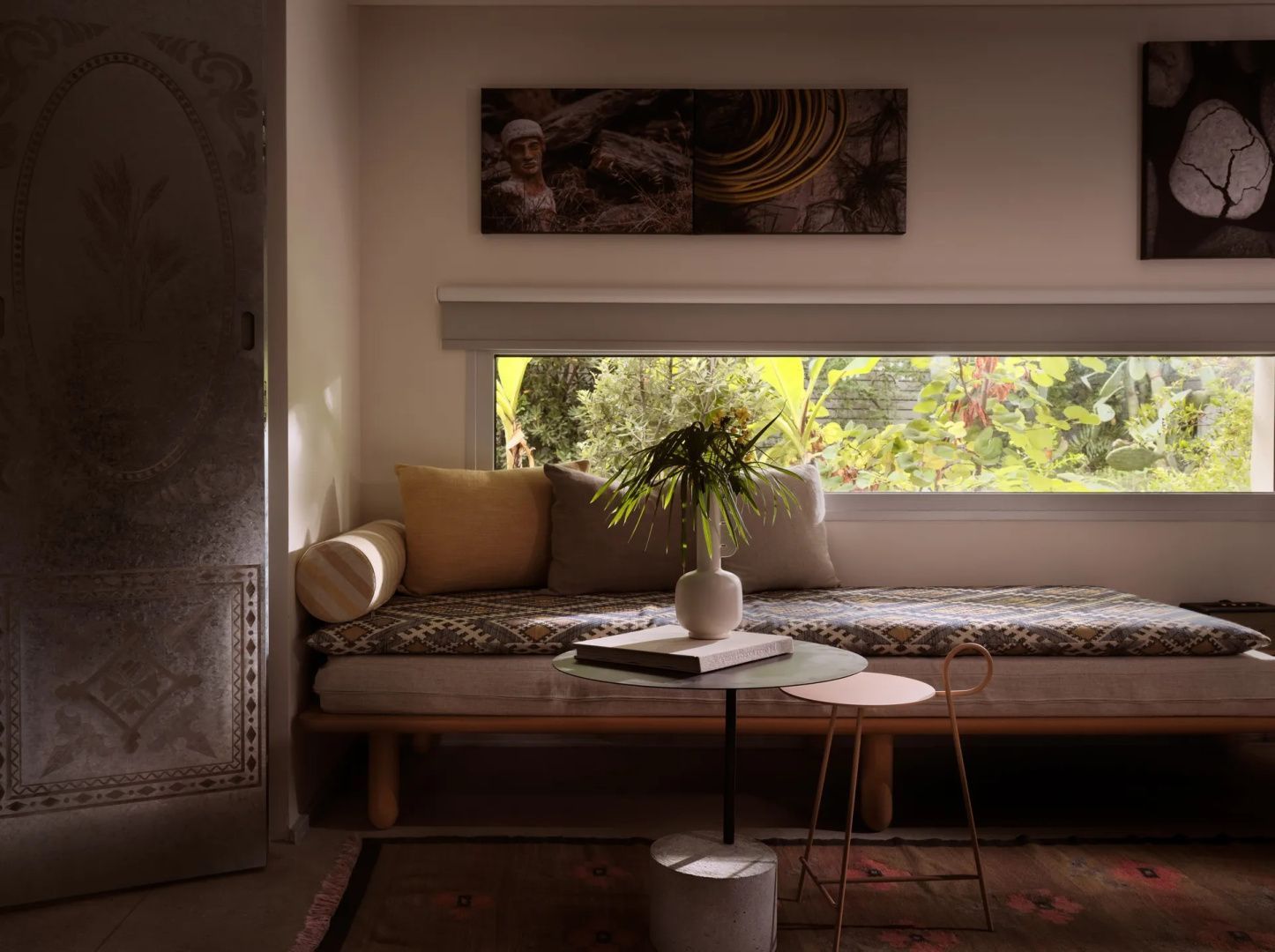 Sitzbereich im Zimmer mit Polsterbank, modernem Beistelltisch und schmalem Panoramafenster.