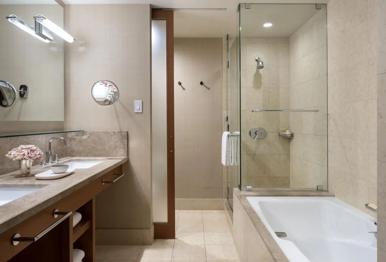 Badezimmer mit großem Waschtisch, verglaster Dusche und Badewanne.