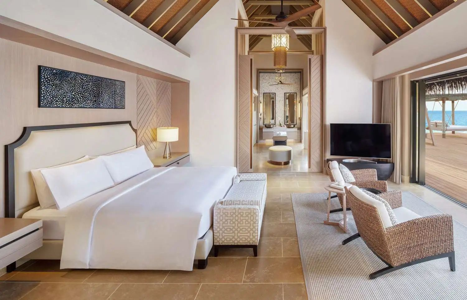 Großzügiges Schlafzimmer einer Villa mit Doppelbett und hoher Holzdecke.