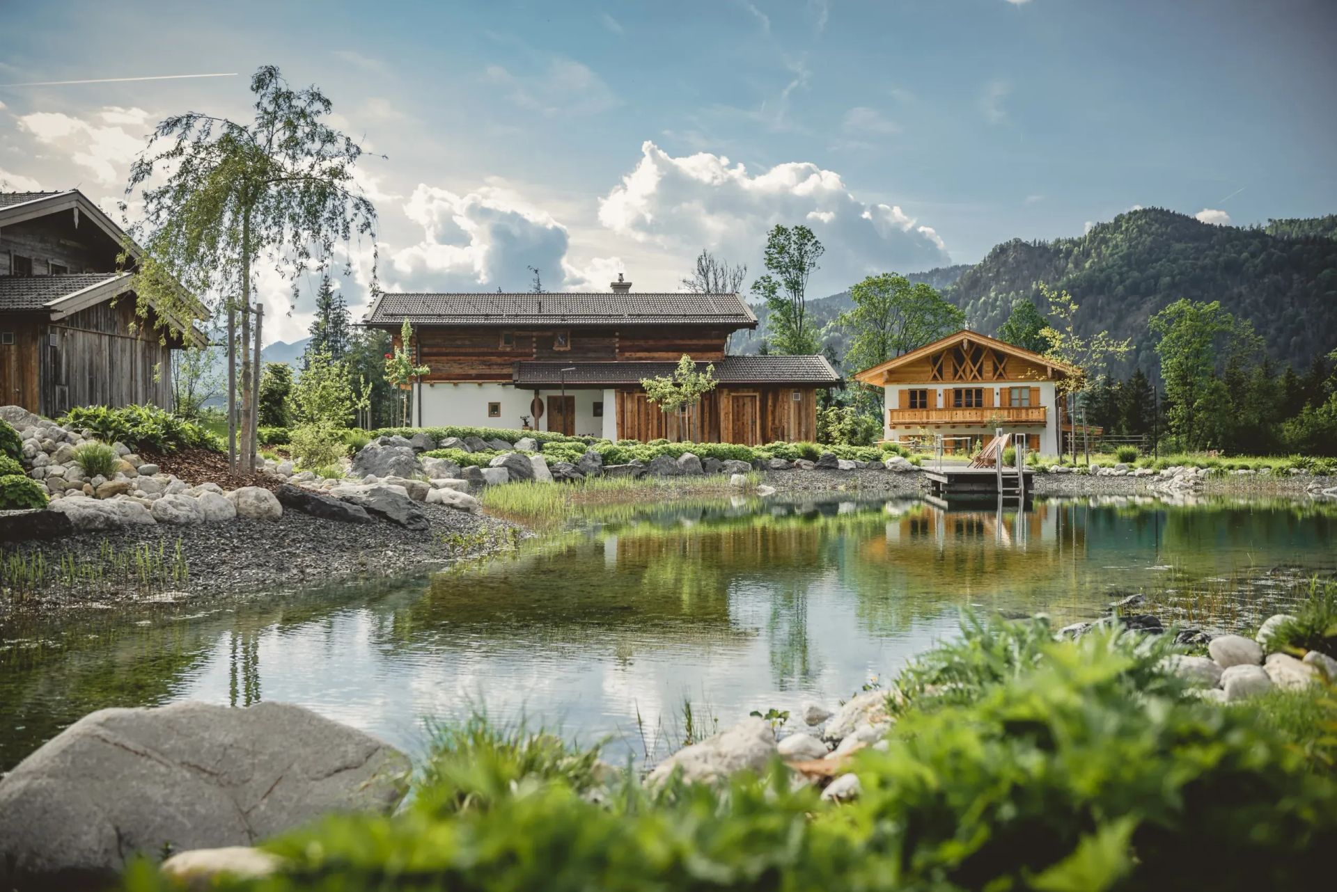 Alpenchalets am See mit Bergen im Hintergrund und reflektierendem Wasser im Vordergrund