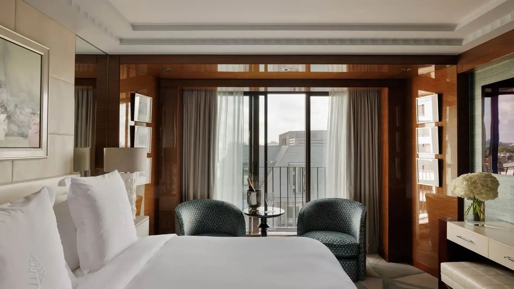Sitzbereich im Hotelzimmer mit zwei Sesseln vor dem Fenster und Blick auf die Stadt.