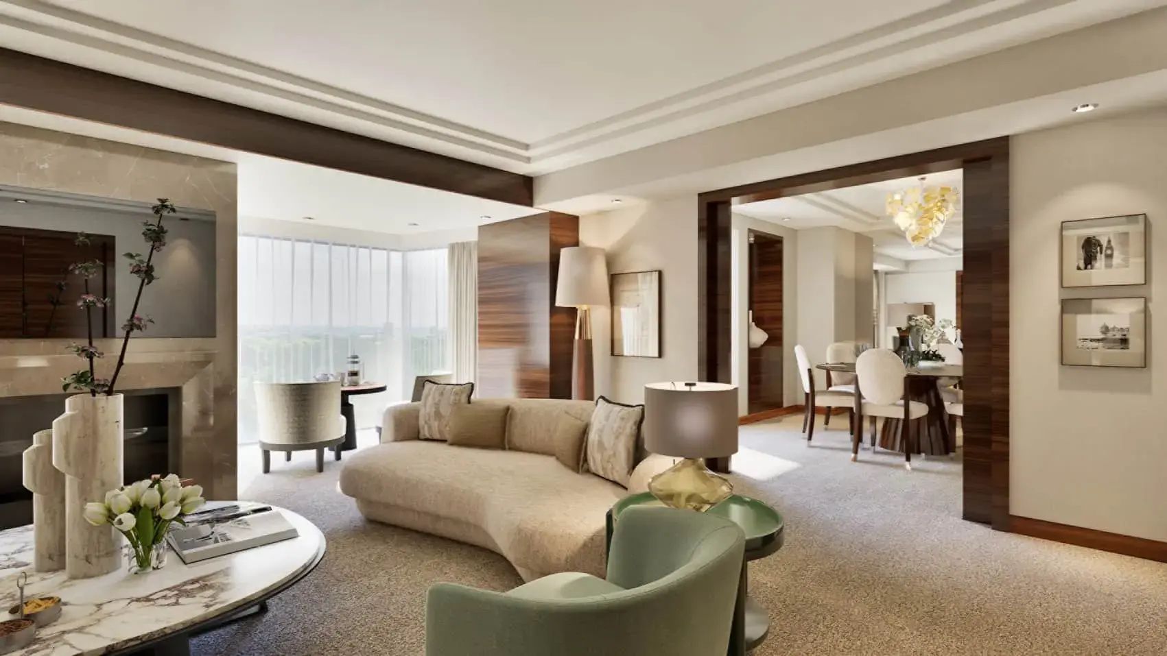 Wohnbereich einer Suite mit geschwungenem Sofa, Sessel und Blick durch das Fenster.