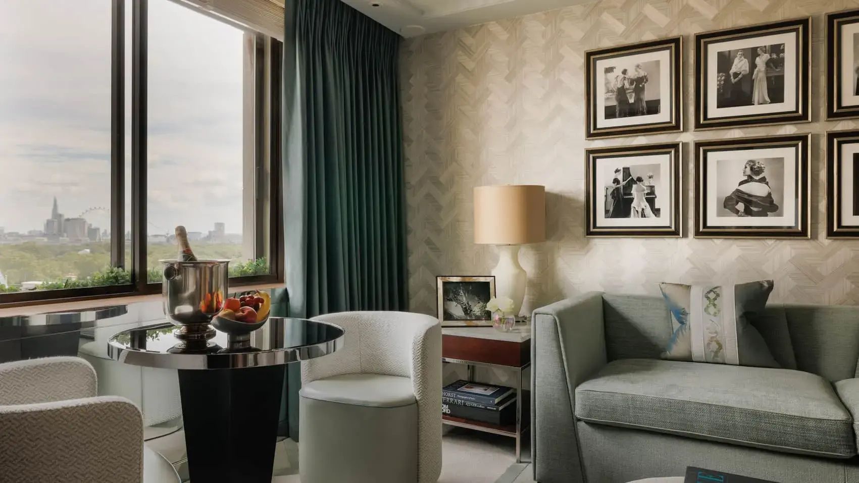 Sitzbereich im Hotelzimmer mit grünem Vorhang, Sessel, Tisch und Blick nach draußen.