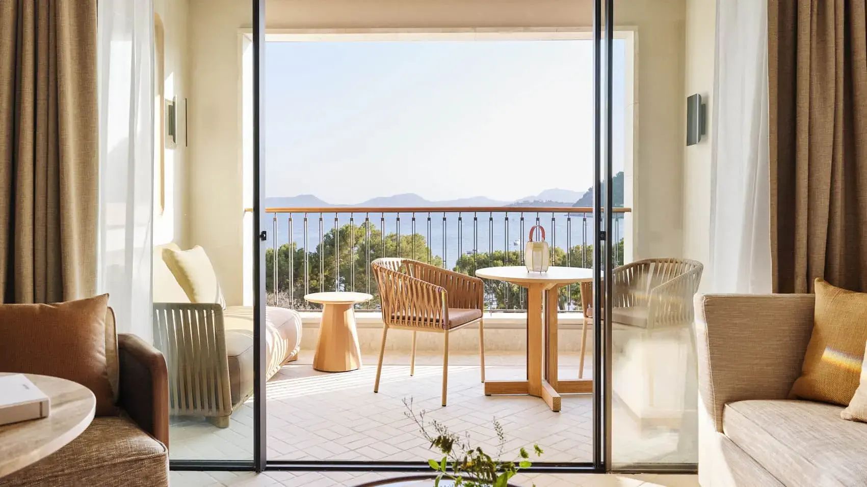 Möblierter Balkon mit zwei Stühlen, Tisch und Blick auf das Meer.