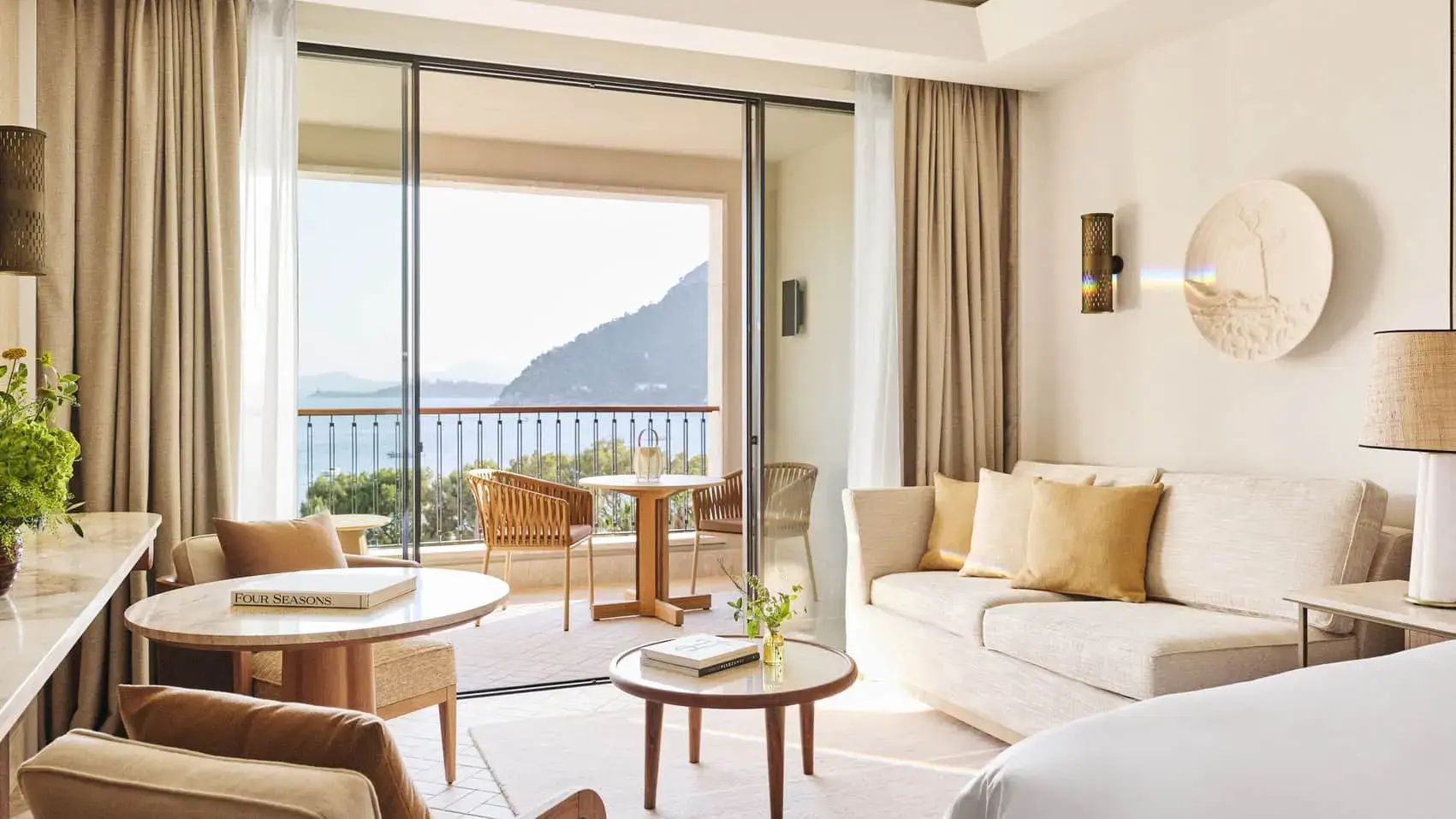 Wohnbereich eines Hotelzimmers mit Sofa und Schiebetür zum Balkon.