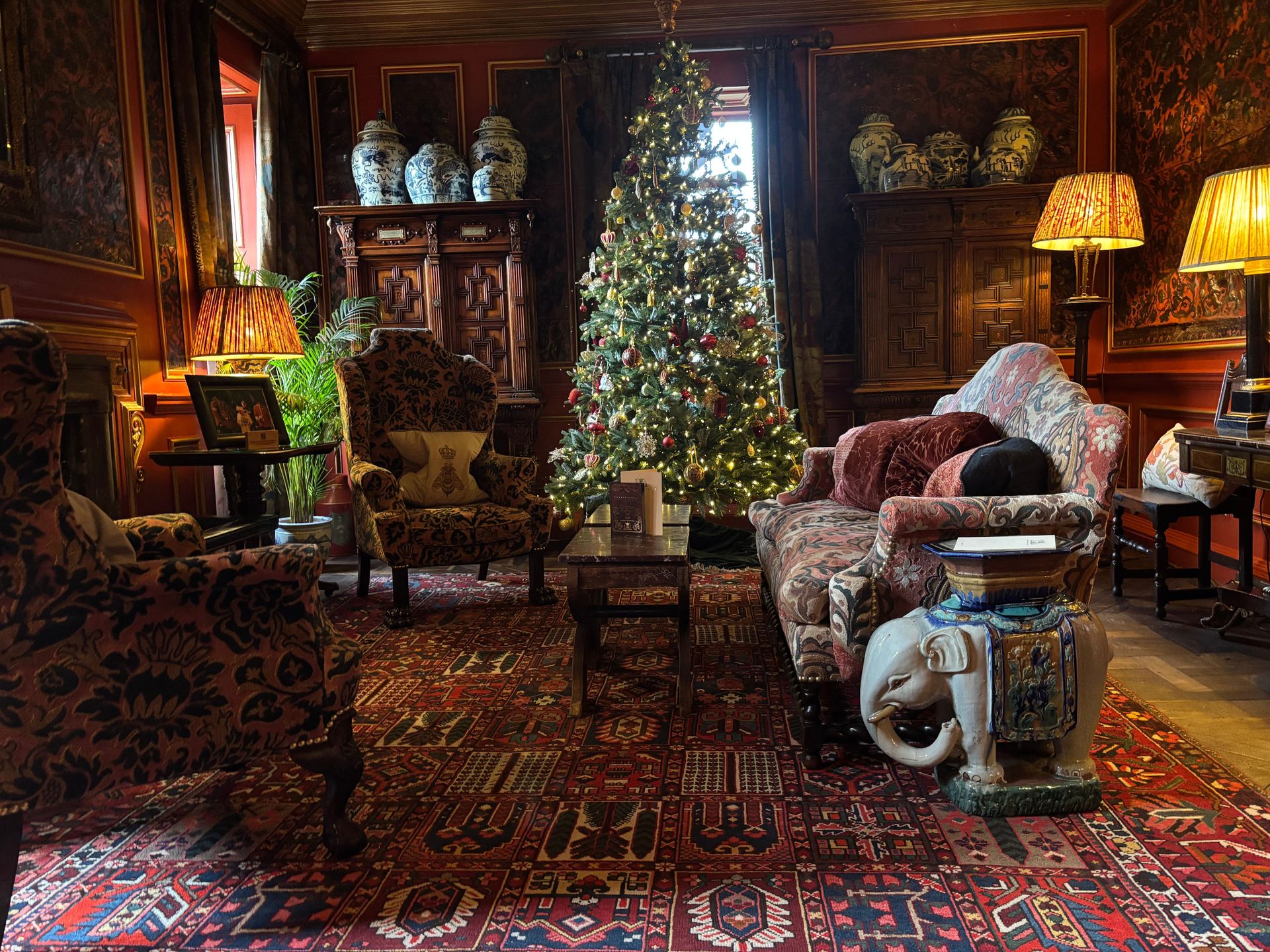 Luxuriöses Wohnzimmer mit Weihnachtsbaum, alten Möbeln und orientalischem Teppich