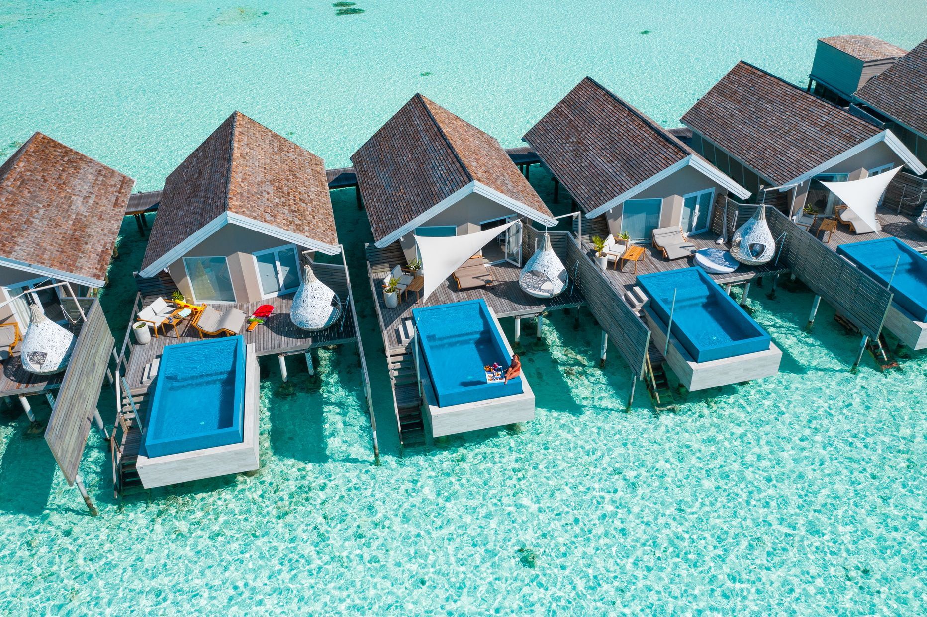Reihen von Wasserbungalows mit Privatpools im türkisfarbenen Meer