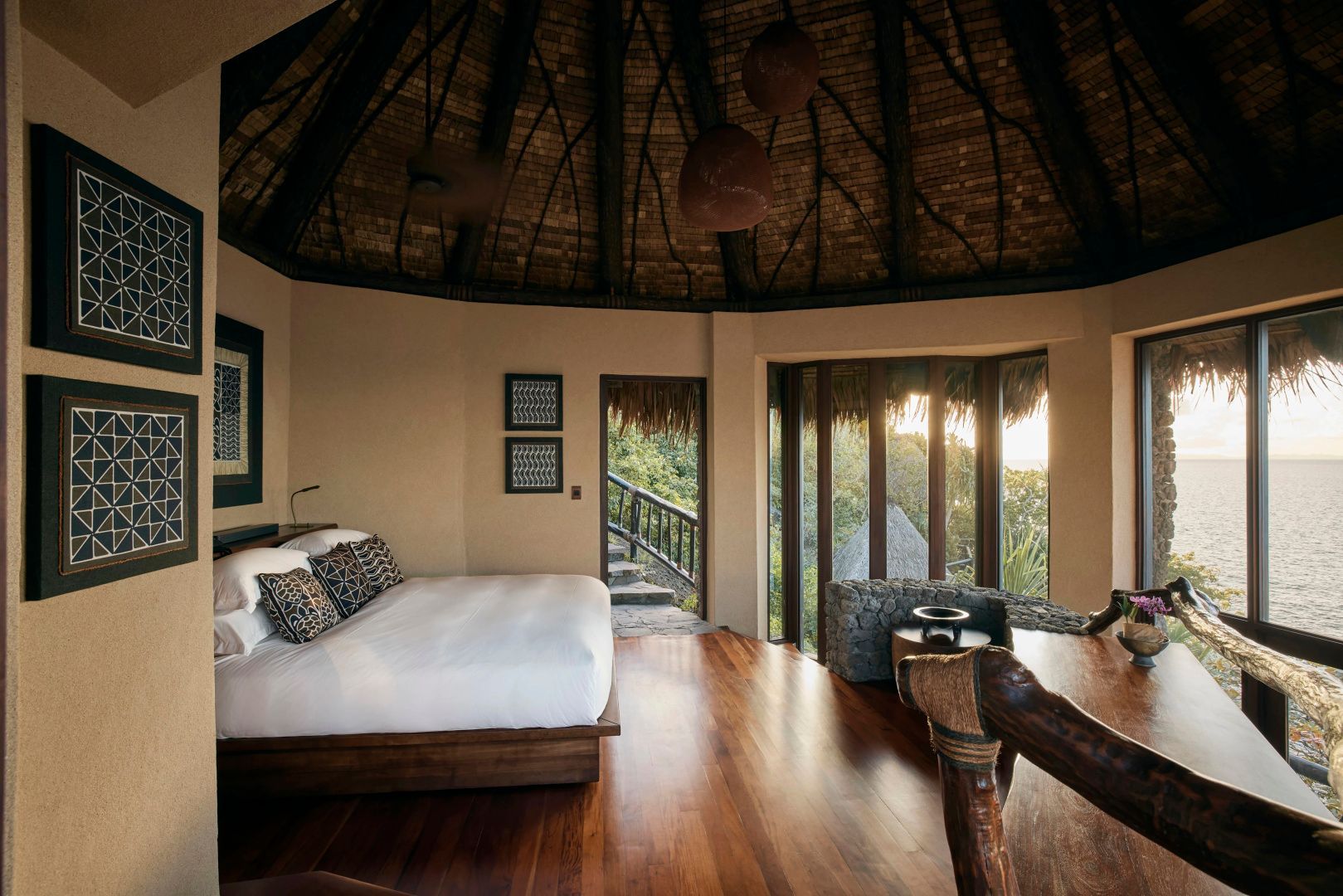 Schlafzimmer in einem Bungalow mit Reetdach, Parkettboden und Blick ins Grüne.